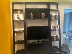 une étagère noire avec une télévision à écran plat dans l'établissement Rotonda City Center, à Thessalonique