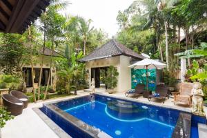 a swimming pool in front of a villa at Bakti Villa in Ubud