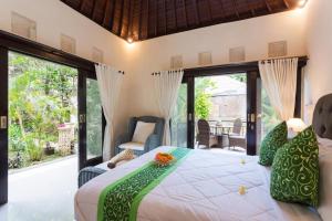 1 dormitorio con 1 cama en una habitación con puertas correderas de cristal en Bakti Villa en Ubud