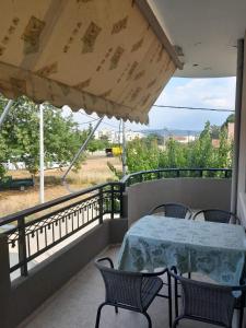 a balcony with a table and chairs and a view of a field at Evelins house Alexandroupoli in Alexandroupoli