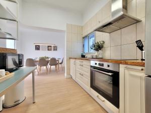 a kitchen with a stove top oven next to a table at Palm Street Apartment in Puerto de la Cruz