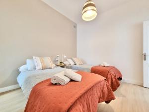 two beds with towels on them in a bedroom at Palm Street Apartment in Puerto de la Cruz
