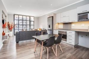 a kitchen and dining room with a table and chairs at The Galleries Serviced Apartments in Rosebank in Johannesburg