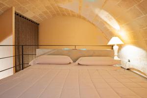 1 dormitorio con 1 cama en una pared de ladrillo en Ai Quarti Sottani, en Matera