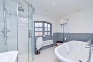 La salle de bains est pourvue d'une baignoire, d'une douche et d'un lavabo. dans l'établissement Victorian townhouse - Stamford centre - 2 big bedrooms, living room kitchen etc tastefully decorated, à Lincolnshire