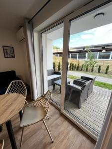 a room with a sliding glass door with a table and chairs at Apartamenty pod Modrzewiem in Ustronie Morskie