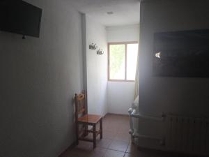 a small room with a chair and a window at Hostal El Desvío in Sierra Nevada