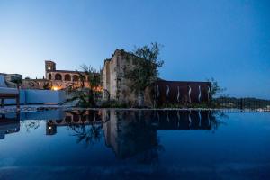 uma piscina de água com um edifício ao fundo em Hotel Forn Nou em Artá