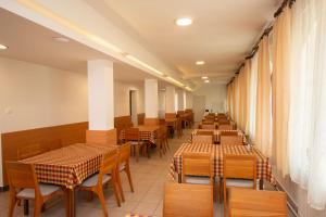 une rangée de tables et de chaises dans un restaurant dans l'établissement Laterum Motel, à Orfű
