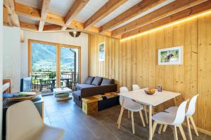 a living room with a table and a couch at Villa mitoyenne proche des bains in Saillon