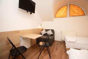 a small room with a desk and a bed at Laterum Motel in Orfű