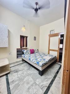 Schlafzimmer mit einem Bett und einem Deckenventilator in der Unterkunft Namaste Amritsar Homestay in Amritsar