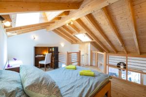 薩永的住宿－Villa mitoyenne proche des bains，一间带一张床的卧室,位于带木制天花板的房间内
