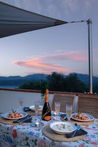 una mesa con platos de comida y una botella de vino en Borgo dei Fiori - Homey Experience, en Cugnana
