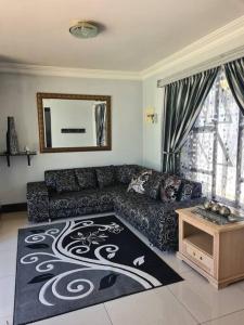 sala de estar con sofá y alfombra en Umhlanga Guesthouse flat, en Durban
