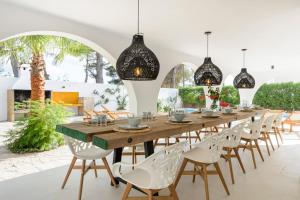 jadalnia z długim drewnianym stołem i krzesłami w obiekcie Villa Maria - Luxury Getaway w mieście Ses Paisses