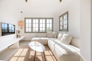 a white living room with a couch and a table at Villa Maria - Luxury Getaway in Ses Paisses