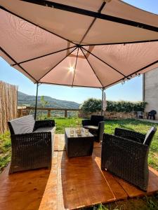 a patio with a table and chairs under a large umbrella at Casa David in Santa Liña