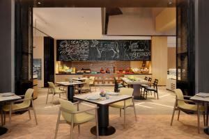 a restaurant with tables and chairs and a chalkboard at Delta Hotels by Marriott Xi'an in Xi'an
