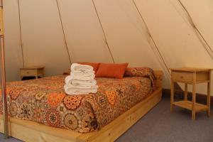 einen Haufen Handtücher auf einem Bett in einem Zelt in der Unterkunft Casas Rurales el Nogalejo Setenil in Setenil de las Bodegas