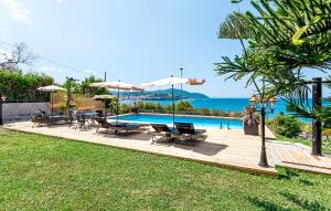 a swimming pool with chairs and umbrellas and the ocean at MaryWilliam in Agropoli