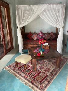 a living room with a table and a couch at Casa Paradis in Jambiani