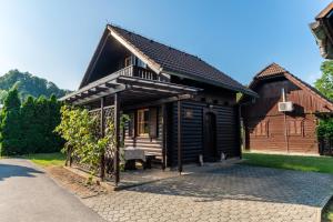 a wooden house with a bench in front of it at Bella Mura Nature Chalet I27 in Podčetrtek