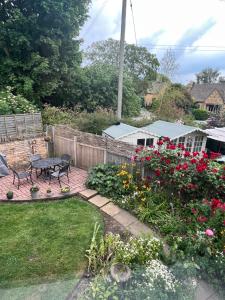 a garden with a bench and a bunch of flowers at Church View in Weston Subedge