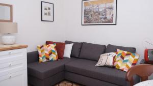 a living room with a gray couch with colorful pillows at Casa Busciana in Olmedo