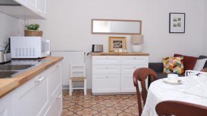 a kitchen with white cabinets and a table with a dining room at Casa Busciana in Olmedo