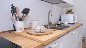 a kitchen counter with a cutting board and a sink at Casa Busciana in Olmedo