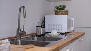 a kitchen counter with a sink and a microwave at Casa Busciana in Olmedo +22 photos