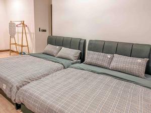 dos camas sentadas una al lado de la otra en una habitación en [Starry x CREAM] Sea View Apartment 10-12pax *FREE Netflix en Masai