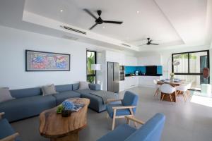 a living room with a blue couch and a table at Villa La Moon Chaweng Noi 4BR in Koh Samui