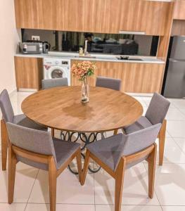 una mesa de madera con sillas y un jarrón con flores en [Starry x CREAM] Sea View Apartment 10-12pax *FREE Netflix en Masai