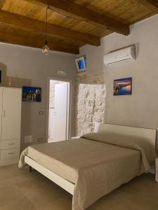 ein Schlafzimmer mit einem Bett und einer Steinmauer in der Unterkunft Casolare 67 in Noci