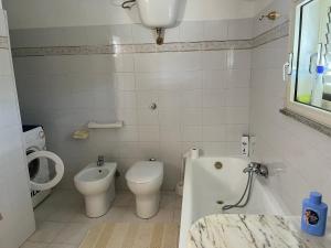 y baño con aseo, bañera y lavamanos. en Casa Vacanze M en Bagnara Calabra