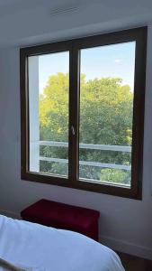1 dormitorio con ventana y vistas a los árboles en Apartment 2 bedroom with parking, pool and tennis, en Le Chesnay