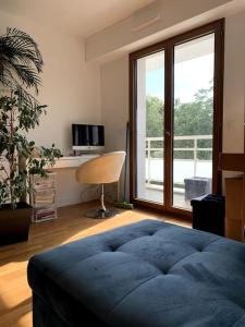 Un dormitorio con una gran cama azul y una ventana en Apartment 2 bedroom with parking, pool and tennis, en Le Chesnay