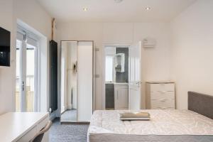 a white bedroom with a bed and a bathroom at City Travellers Luxury 2 Beds Apt with Private Garden & Wi-Fi- 中国搬迁 in Leeds