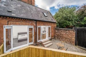 a brick house with sliding glass doors and a patio at City Travellers Luxury 2 Beds Apt with Private Garden & Wi-Fi- 中国搬迁 in Leeds