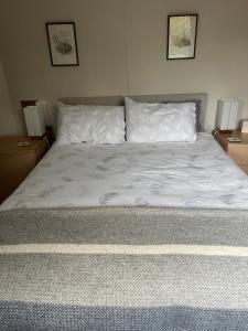 a bed with white sheets and pillows in a bedroom at Church View in Weston Subedge