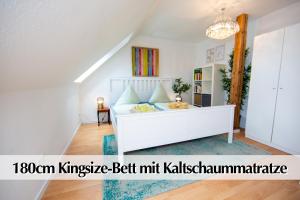 Schlafzimmer mit einem Bett und einem Kronleuchter in der Unterkunft Helles 80m2 Maisonette-Loft mit Balkon, Kingsize Bett, Smart-TV, etc in Erfurt
