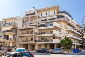 un gran edificio de apartamentos con coches aparcados frente a él en Araucaria Studio near Downtown, en Heraclión