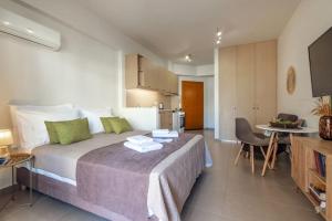 1 dormitorio con 1 cama grande y cocina en Araucaria Studio near Downtown, en Heraclión