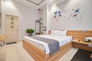 um quarto com uma cama grande e flores na parede em Bin Bin Hotel 2 - Near Him Lam D7 em Ho Chi Minh