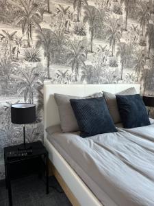 a bedroom with a bed with a wall with palm trees at Pensjonat Dom Latarnika in Grzybowo