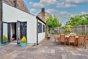 a patio with a table and chairs and a building at Finest Retreats - Quarry Lodge in Wigton