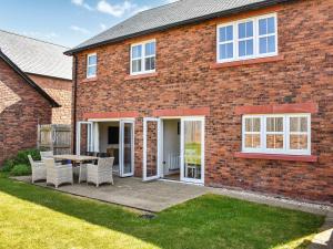 een stenen huis met een patio met een tafel en stoelen bij Centurion Rise in Penrith