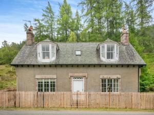 an old house behind a wooden fence at Meall Darroch in Inverey